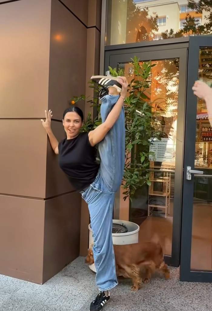 Andreea Popescu ține pe picior un pahar cu apă
