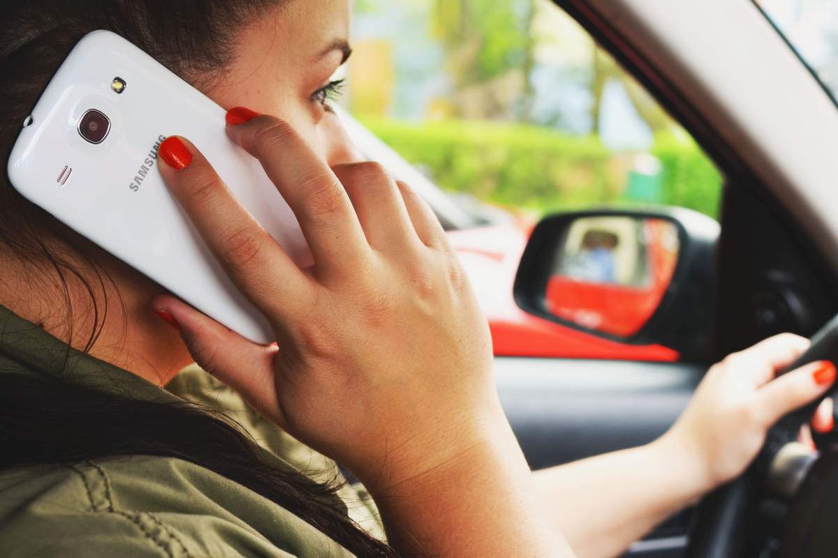 Imagine ilustrativă cu o femeie care vorbește la telefon, în timp ce se află la volan