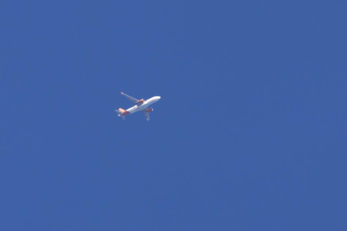 Avion de pasageri Airbus al companiei aeriene EasyJet zburând pe un cer albastru, Anglia, Regatul Unit