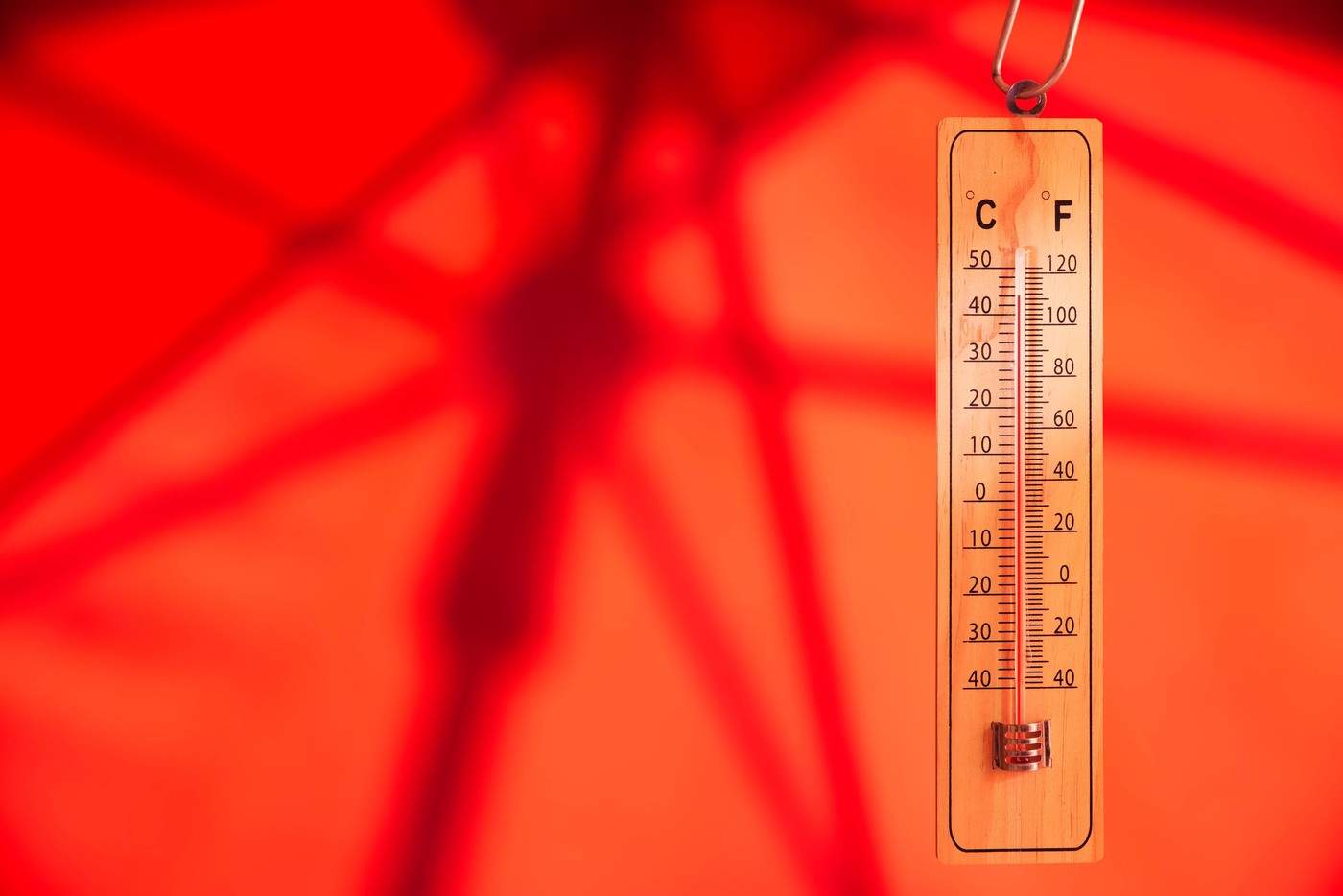 o umbrelă de soare și un termometru care indică o temperatură extrem de ridicată – concept privind încălzirea globală și schimbările climatice; spațiu liber