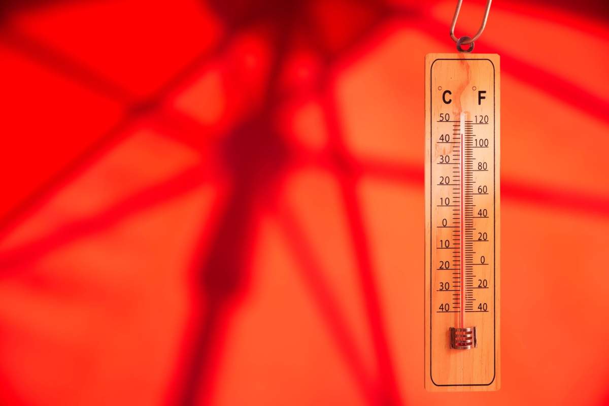 o umbrelă de soare și un termometru care indică o temperatură extrem de ridicată – concept privind încălzirea globală și schimbările climatice; spațiu liber