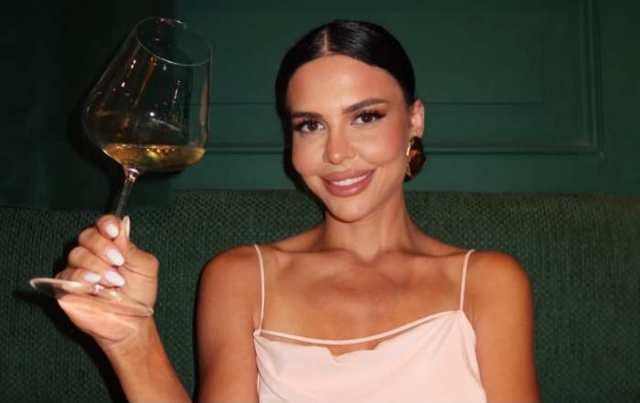 Andreea Popescu, cu un pahar de vin în mână