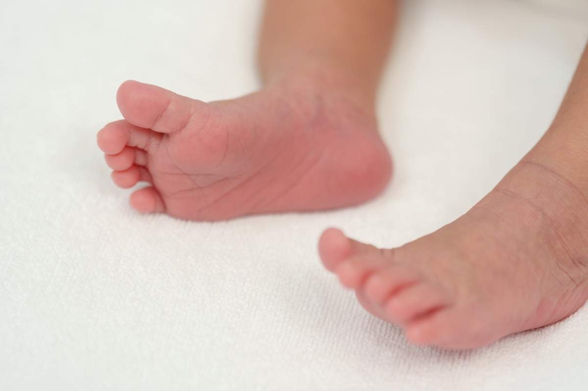 Prim-plan cu picioarele unui nou-născut pe un pat