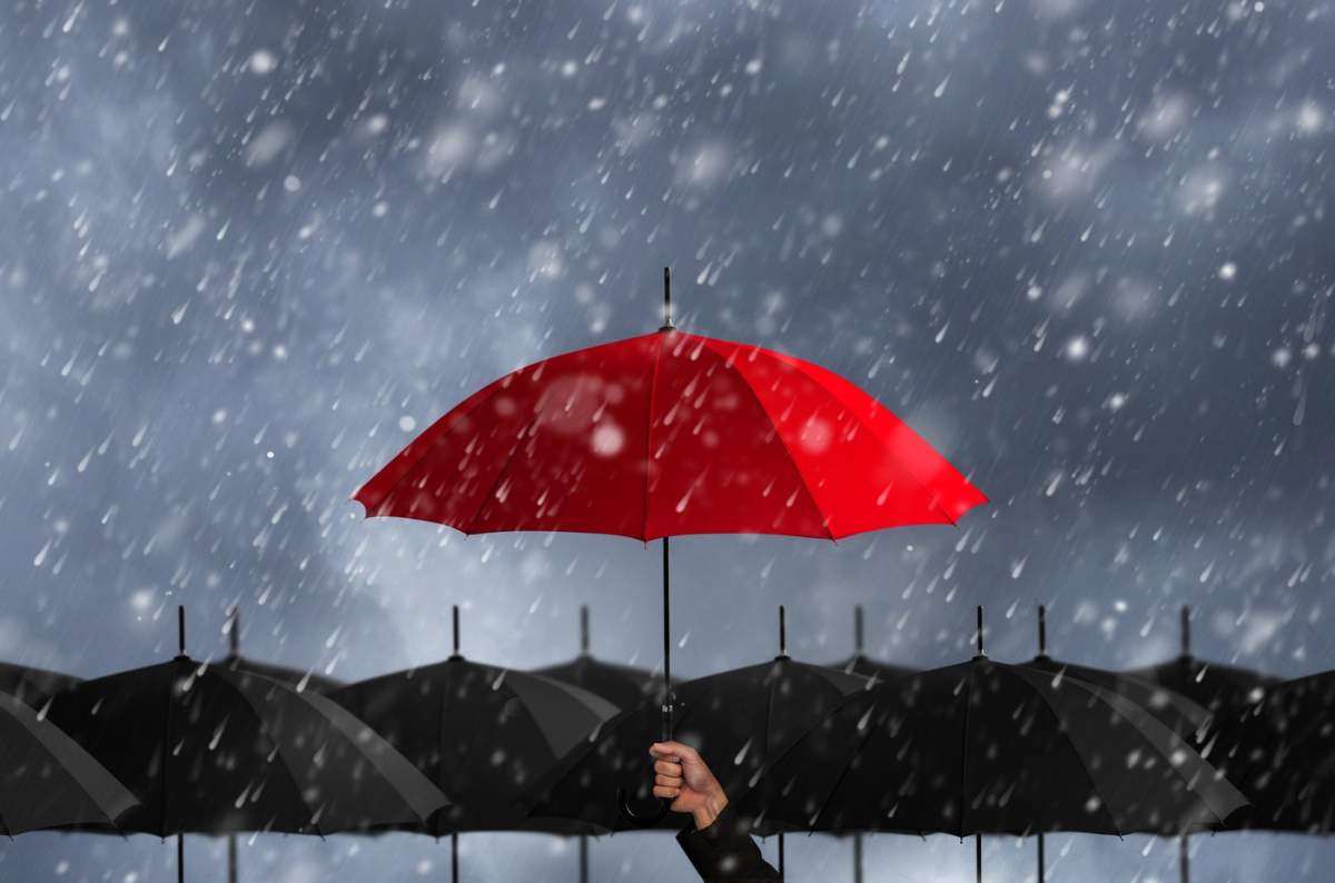 O umbrelă roșie într-o mare de umbrele negre... O umbrelă roșie în furtună.