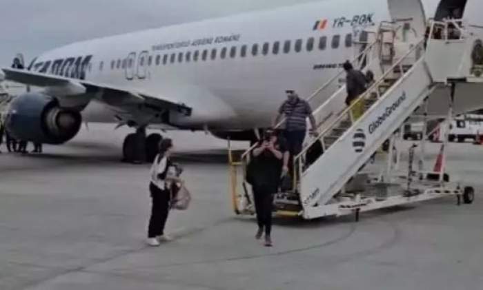 Pasagerii coboară din avion