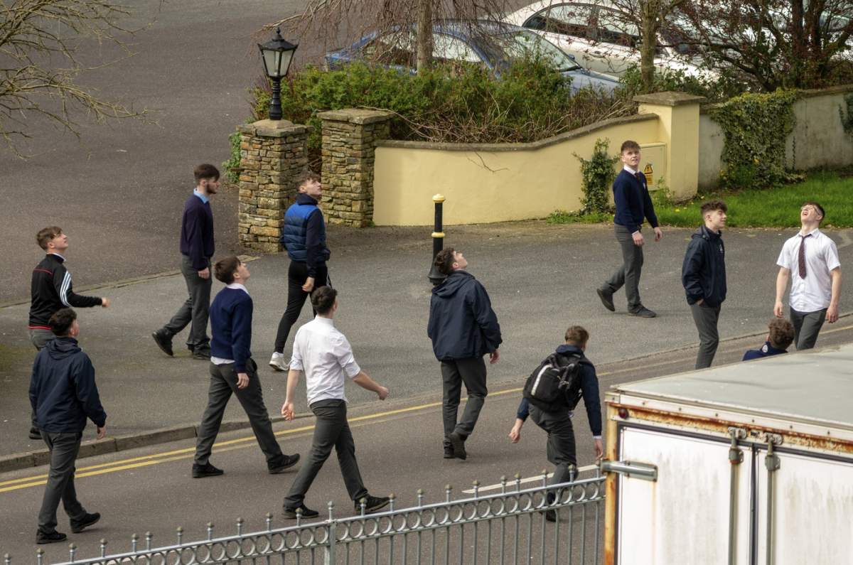 Un grup de studenți irlandezi de sex masculin care se plimbă și își petrec timpul liber pe străzi, între ore. Educație în Irlanda. Timpul liber al studenților