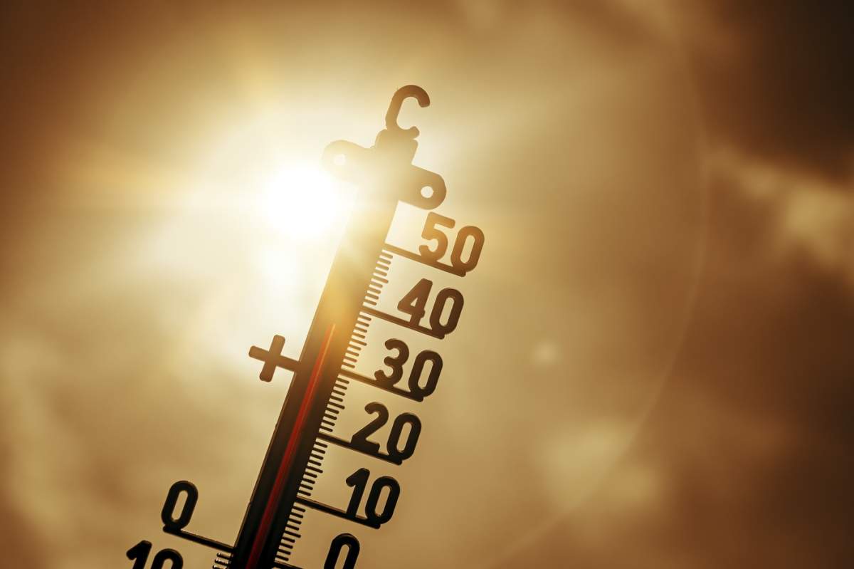 Termometru expus la soare puternic indică temperaturi ridicate; fotografie simbolică pentru val de căldură, fotomontaj +++ doar pentru uz editorial